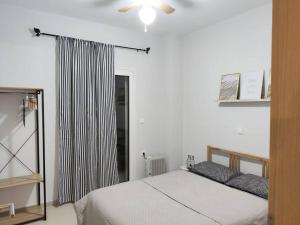 a bedroom with a bed and a window with a curtain at Litohome Litochoro The Gods Oasis in Litochoro