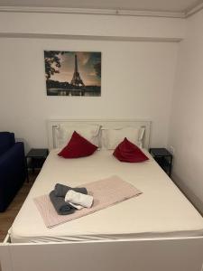 ein Bett mit Handtüchern und ein Bild des Eiffelturms in der Unterkunft Tranzzit Airport Apartament I in Otopeni