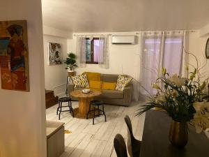 Appartement dans quartier historique de Mouans-Sartoux في موانس سارتوكس: غرفة معيشة مع أريكة وطاولة
