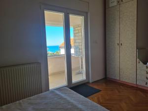 a room with a sliding glass door with a view of the ocean at Seaview apartment Marta in Crveni Vrh