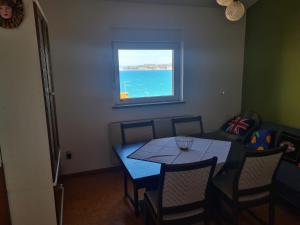 a dining room with a table and a window at Seaview apartment Marta in Crveni Vrh