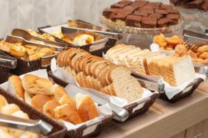 a buffet of different types of bread and pastries at SMART IGUASSU HOTEL in Foz do Iguaçu