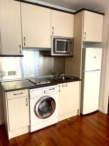 uma cozinha com uma máquina de lavar roupa e um micro-ondas em CUATRO CAMINOS em Madri