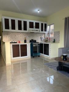 a kitchen with white cabinets and a table in a room at J&W apartment in San Felipe de Puerto Plata
