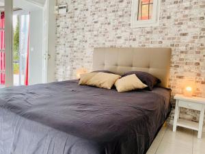 a bedroom with a large bed with a brick wall at Appartement in Flayosc