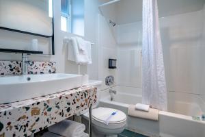 La salle de bains blanche est pourvue de toilettes et d'un lavabo. dans l'établissement Seagull Beachfront Inn, à Lincoln City