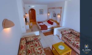een slaapkamer met een bed en een bank in een kamer bij Al Jazira Beach & Spa- All Inclusive - Families and Couples Only in Houmt Souk