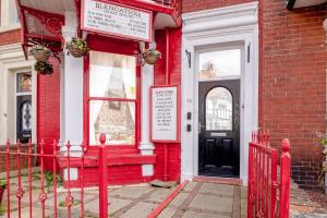 a red house with a red door and a window at Blencathra in Whitby