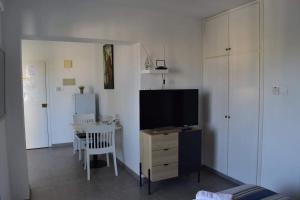 a living room with a television and a table with a chair at Maria Holiday Apartments in Protaras