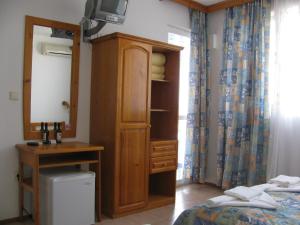 a bedroom with a cabinet and a bed and a television at Villa Sens in Chernomorets