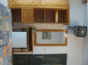 a kitchen with wooden cabinets and a mirror at Villa Sens in Chernomorets