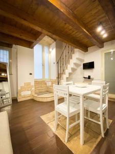 una mesa blanca y sillas en una habitación con escaleras en Casa Pachira (Borgo Antico) en Bari