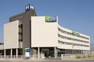 un bâtiment avec un panneau sur son côté dans l'établissement Holiday Inn Express Molins de Rei, an IHG Hotel, à Molins de Rei