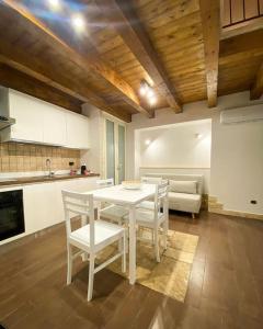 cocina con mesa blanca, sillas y sofá en Casa Pachira (Borgo Antico) en Bari
