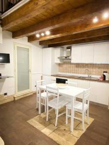 cocina con mesa blanca y sillas blancas en Casa Pachira (Borgo Antico) en Bari