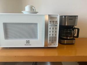 a microwave sitting on a table next to a coffee maker at Praia do Canto Apart Hotel Frente Mar in Vitória