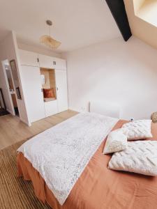 1 dormitorio blanco con 1 cama grande y 2 almohadas en Duplex neuf centre ville avec parking, en Neauphle-le-Château