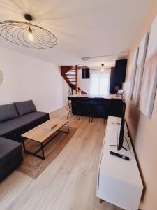 sala de estar con sofá y mesa en Duplex neuf centre ville avec parking en Neauphle-le-Château