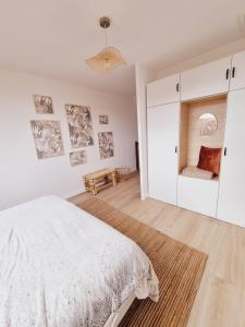 a white bedroom with a bed and a couch at Duplex neuf centre ville avec parking in Neauphle-le-Château