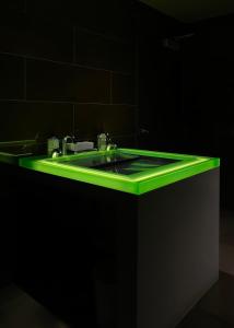 a green sink in a black bathroom at SIRTAJ – Beverly Hills in Los Angeles