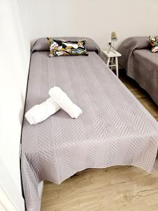 a bed with two pillows on top of it at Apartamento Familiar en Triana in Seville