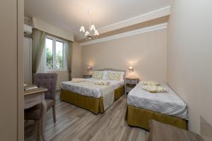 a hotel room with two beds and a desk at A Casa Di... Aurora 2 in San Vito lo Capo