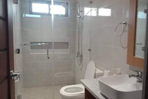 y baño con ducha, aseo y lavamanos. en Brand new house with 3-bedroom and free parking en Guiguinto