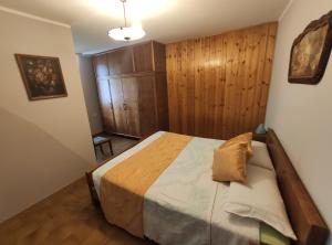 - une chambre avec un lit et un mur en bois dans l'établissement Agriturismo Ribuntà, à Caiolo