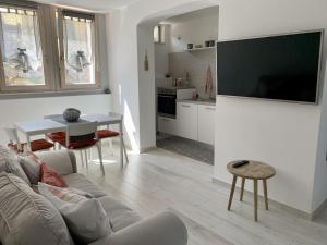 a living room with a couch and a tv on a wall at Casa Manila Isola d'Elba in Portoferraio