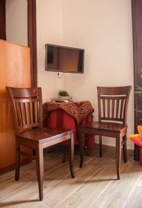 Zimmer mit 2 Stühlen und einem Tisch mit einem TV in der Unterkunft Parthenope's home in Neapel