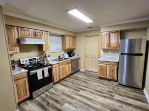 eine Küche mit Holzschränken und Küchengeräten aus Edelstahl in der Unterkunft s2. Lakeside house in Scottsboro in Scottsboro