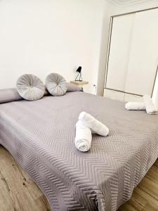 a bed with two pillows on top of it at Apartamento Familiar en Triana in Seville +19 photos