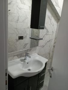 a bathroom with a white sink and a mirror at Apartmani kod Rade in Pakoštane