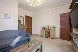 a living room with a blue couch and a table at Spartacus Apartment in Alexandroupoli