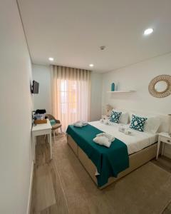 a bedroom with a large bed with a green blanket at Pátio 29 - Guest House in Viana do Castelo