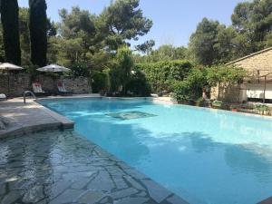 a large swimming pool with blue water at Villa de 5 chambres avec piscine privee et jardin clos a Orgon in Orgon