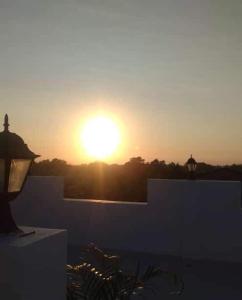 un coucher de soleil sur un bâtiment avec le soleil dans le ciel dans l'établissement Melvince Lodging House, à Vigan