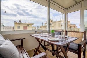 a table on a balcony with a large window at Spartacus Apartment in Alexandroupoli