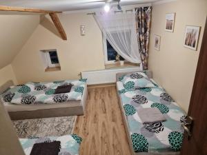 a bedroom with two beds and a window at Asieńka 1 in Mirsk