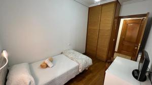 a small bedroom with a bed with a teddy bear on it at Pensión Buen Camino in Estella