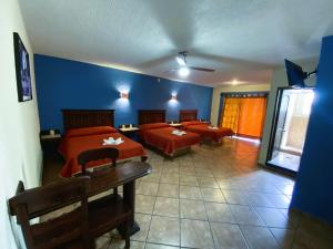 ein Schlafzimmer mit 2 Betten und einer blauen Wand in der Unterkunft Hotel Cabañas Santa Cruz in Oaxtepec