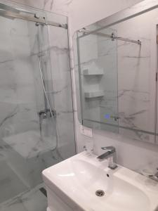 een witte badkamer met een wastafel en een douche bij White King in Tbilisi City