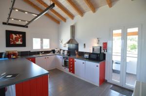 a large kitchen with red and white cabinets at House of the Barrel Maker in Sfakerá