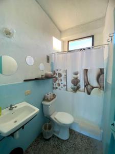 a bathroom with a white toilet and a sink at Habitación Privada en Flores in Flores