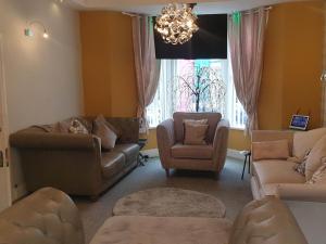 a living room with couches and chairs and a chandelier at The Chorlton by Cherish Lewis Hotel in Blackpool