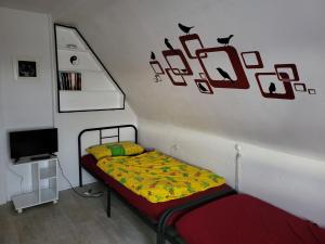 1 dormitorio con cama y pared con adornos de aves en Ferienhaus Keppler im Erzgebirge, en Sayda