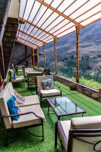 an outdoor patio with chairs and a glass table at Altar Inca Hotel Mirador in Cusco