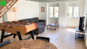 a living room with a couch and a table with a chessboard at Le Chill Loft in Miramont-de-Guyenne