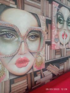 a mural of a woman wearing sunglasses at Alice nel paese delle meraviglie 