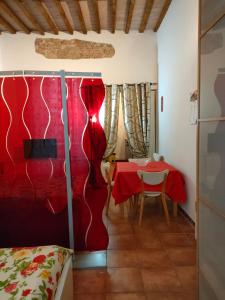 una habitación con una mesa y una cortina roja en Mini appartamento en Livorno